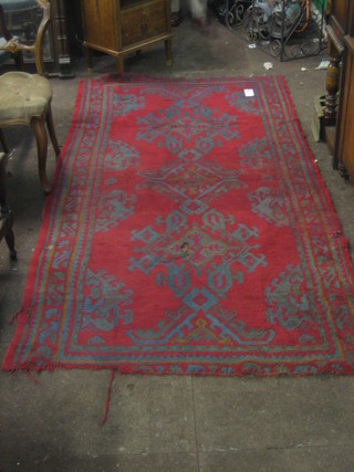 A contemporary red ground Persian rug with diamond field to the centre and all over geometric design 81" x 49"