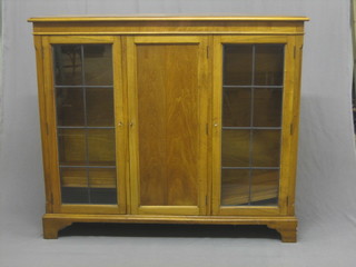 A  1930's  walnut  display cabinet, the  interior  fitted  adjustable shelves enclosed by lead glazed panelled doors, raised on  bracket  feet 53"