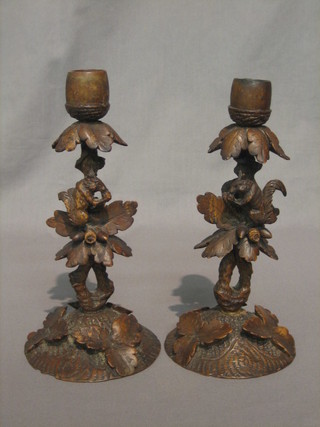A   handsome   pair  of  17th/18th  Century   carved   walnut candlesticks  in  the  form of branches, each  carved  leaves  and squirrels,  raised on circular carved bases with leaf  decoration  8 1/2"