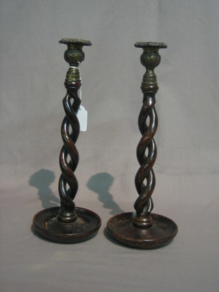 A  pair  of oak pierced and spiral turned candlesticks  with  metal sconces 13"
