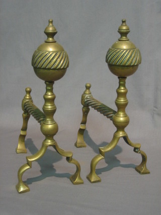 A pair of brass fire dogs with lidded urn decoration