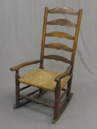 An 18th/19th Century elm ladder back rocking chair with  woven rush seat