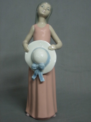 A  Lladro  figure of a standing girl with pink dress  and  hat,  the base incised 6, 10"