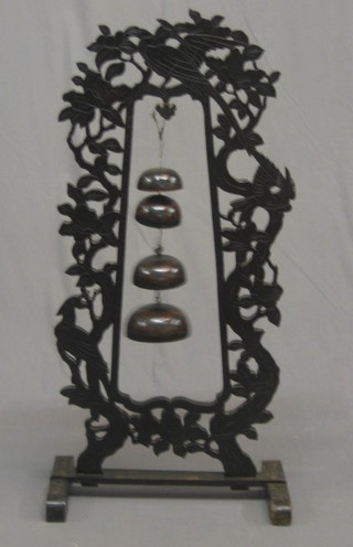 An  Eastern  tea  gong contained in a  pierced  hard  wood  frame