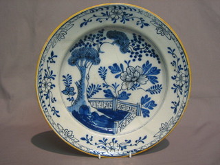 An  18th/19th Century Delft pottery plate decorated a blue  white garden scene 10" (f and r)