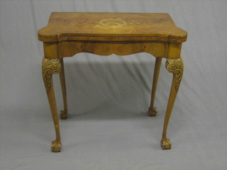 A  1940's  Queen  Anne  style  walnut  card  table  of  serpentine outline, raised on carved cabriole supports 28"