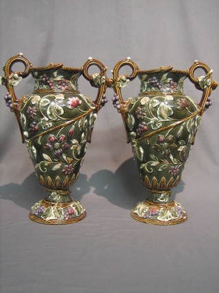 A  pair  of 19th Century Majolica style twin  handled  vases  with floral decoration, the base marked BU, 15"