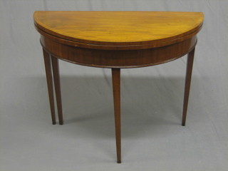 A Georgian mahogany demi-lune card table with crossbanded top and inlaid satinwood stringing, raised on square tapering supports (slight smile to front and old worm to the gate) 36"