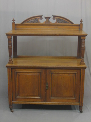A  Victorian  walnut  buffet  with raised back,  the  base  fitted  a cupboard and raised on turned and reeded supports 42"