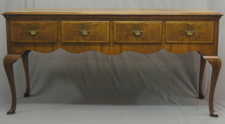A  20th  Century  Queen  Anne  style  walnut  dresser  base  with crossbanded   top  above  4  short  drawers,  raised   on   cabriole supports 67"