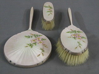 A silver and pink enamelled 3 piece dressing table set comprising hand mirror, hair brush and clothes brush, Birmingham 1964