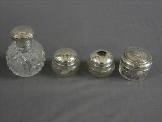 A  cut glass globular shaped scent bottle with hinged silver lid 2", a circular silver dressing table jar with silver lid 3", 2 small dressing table jars  with silver lids 2" (4)