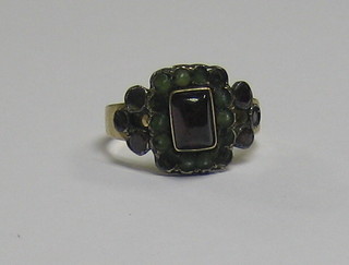 A Georgian gilt metal ring set a rectangular cut red stone supported by demi-pearls