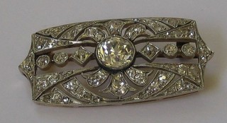 A lady's Art Deco gold rectangular diamond set brooch, set a large diamond to the centre, flanked and supported by numerous diamonds