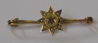 A 9ct gold bar brooch decorated a star set garnet and demi-pearls