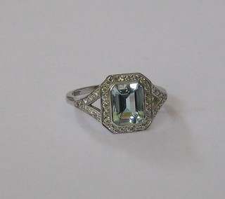 A lady's white gold dress ring set a rectangular cut aquamarine surround by numerous diamonds, approx 1.37ct