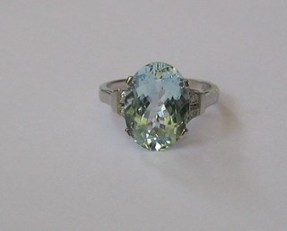 A lady's 18ct gold dress ring set a large oval cut aquamarine supported by 4 diamonds to the shoulders