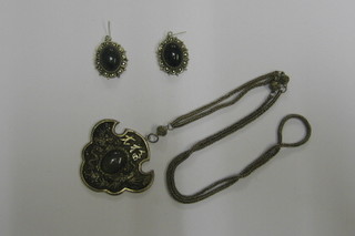An Eastern green and metal suite of jewellery comprising earrings and pendant
