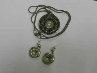 A suite of Eastern white metal and jade coloured jewellery comprising circular pierced pendant and pair of earrings