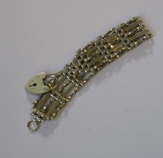 A silver gate link bracelet with heart shaped padlock