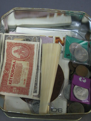A collection of various coins, bank notes and a plastic fan