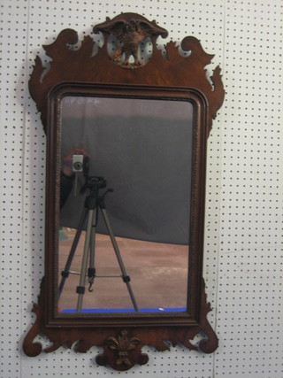 A 20th Century Chippendale style rectangular plate mirror contained in a walnut frame surmounted by a gilt eagle