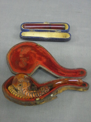 An Eastern carved pipe in the form of a claw holding a pearl together with an amber cigar holder