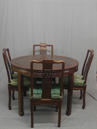 A 20th Century carved Padouk wood dining suite comprising oval extending dining table with 2 extra leaves and 8 dining chairs