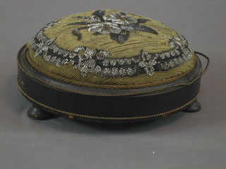 A Victorian circular ebonised footstool with gilt bead work border and upholstered seat, 12"