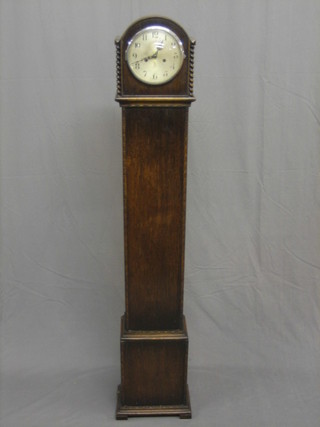 A 1930's striking Granddaughter clock with silvered dial and Arabic numerals, contained in an oak case 61"