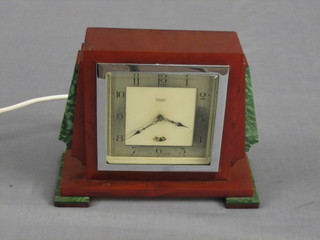 A 1930's Smiths electric clock contained in an amber and green Bakelite case (slight chip to corner of case)