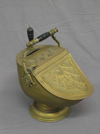 A Victorian embossed brass lidded helmet shaped coal scuttle