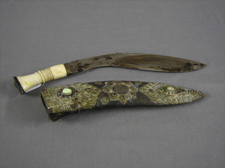 An old Kukri with 12" blade, ivory grip contained in a leather brass and jewel studded scabbard