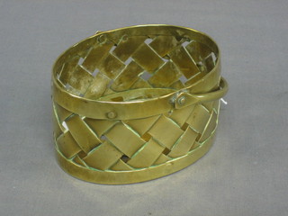 An oval copper pierced basket with swing handle