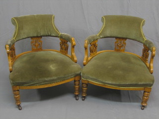 A pair of honey oak show frame tub back chairs with pierced vase shaped splat backs, the seats upholstered in green material and raised on turned supports