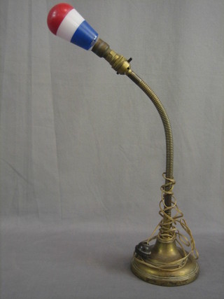 A brass adjustable table lamp with red, white and blue bulb