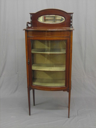 An Edwardian bow front inlaid mahogany display cabinet with raised back, the interior fitted shelves enclosed by a bow front panelled door, raised on square tapering supports 25"