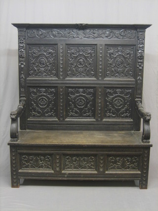 A Victorian heavily carved oak settle with raised back, having lion mask arm rests, 60"