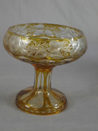 A pedestal amber overlay glass bowl raised on a circular spreading foot 7"