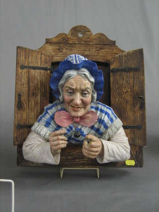 A 19th Century Continental terracotta wall plaque in the form of an elderly lady looking a through shuttered window 14" (chipped)
