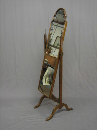 An arched plate cheval mirror contained in a mahogany swing frame
