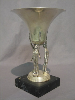 A trumpet shaped silver plated trophy supported by 3 athletes and raised on a marble base 13"