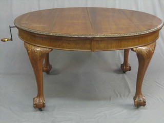 A 1920's Georgian style walnut oval extending dining table, raised on cabriole ball and claw supports with 1 extra leaf 55"