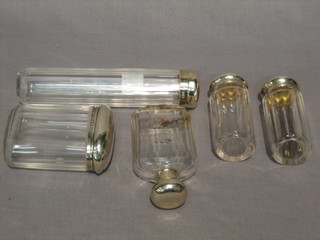 An octagonal cylindrical cut glass dressing table jar with silver lid 7" and 4 other dressing table jars with silver lids 3 1/2"