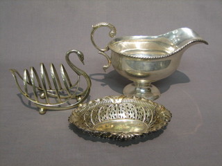 A large silver plated sauce boat, a 5 bar toast rack in the form of a swan and an oval pierced metal dish