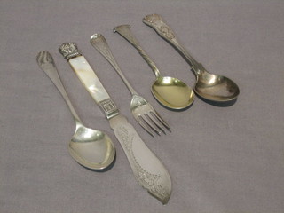 A silver bladed butter knife with mother of pearl handle, a silver fork and 3 silver spoons