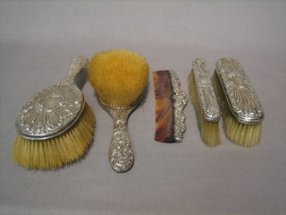 An Edwardian embossed silver 3 piece dressing table set, London 1909 with pair of hair brushes, clothes brush together with a similar clothes brush and comb