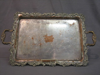 A silver plated twin handled tea tray with cast borders and armorial decoration 19"
