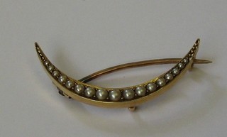A lady's gold crescent shaped brooch set demi-pearls 