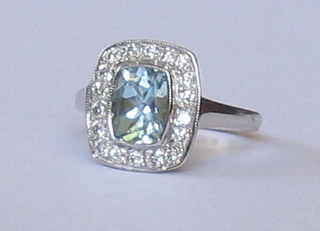 A lady's 18ct white gold dress ring set an oval cut aquamarine supported by diamonds
